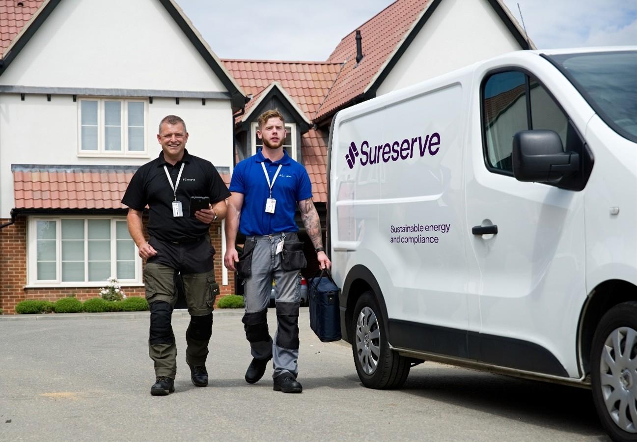 2 SureServe Employees standing beside a White Van outside a house