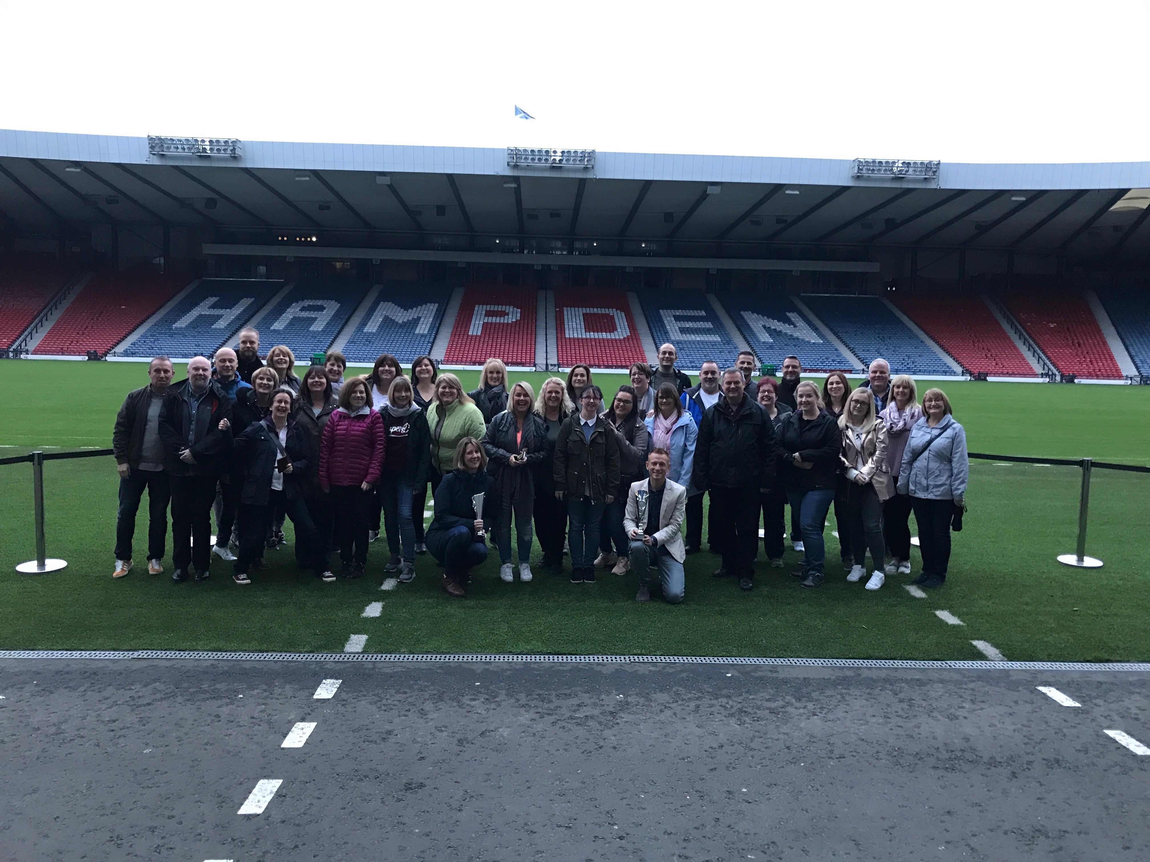 Staff team pitchside at Hampden Stadium